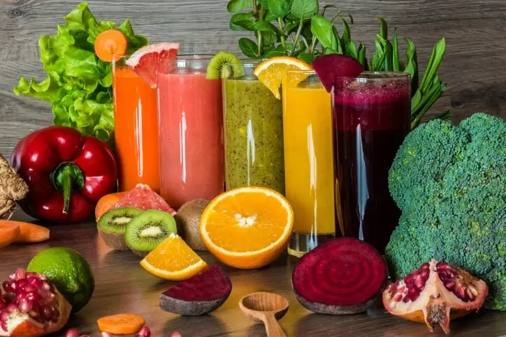 a group of glasses of juice and fruits